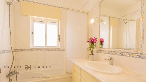 a white bathroom with a sink and a mirror at GREICE HOMES 1 BEDROOM APARTMENT CENTRE OF VILAMOURA in Vilamoura