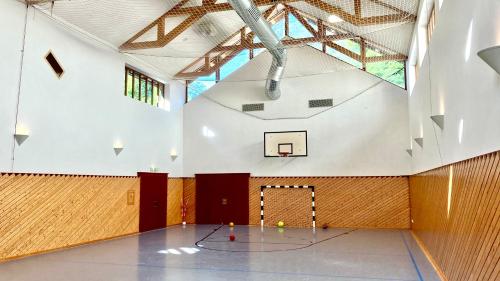 a gym with a basketball hoop in a building at ALPEN EXPERIENCE - CVJM Aktivzentrum Hintersee, Jugendgästehaus in Ramsau