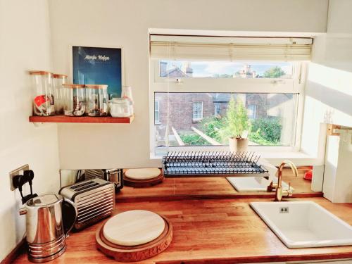 a kitchen with a counter with a sink and a window at Upscale Family Home Beautiful Setting in Woolton