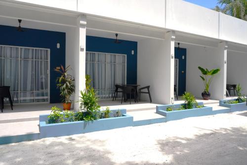 a house with blue and white walls and plants at TME Retreats Dhigurah in Dhigurah