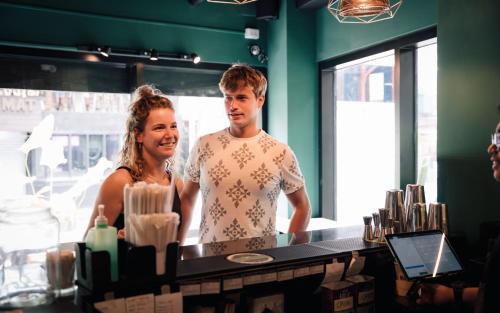 a man and a woman standing behind a counter at Mad Monkey Manila in Manila
