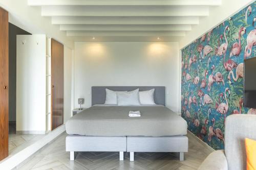 a bedroom with a bed with a painting on the wall at Quill Gardens Boutique Hotel in Oranjestad