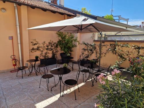 a patio with tables and chairs and an umbrella at La Ca' di sogn in Pavia