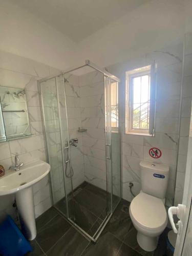 a bathroom with a shower and a toilet and a sink at Mariana Apartments in Sarandë