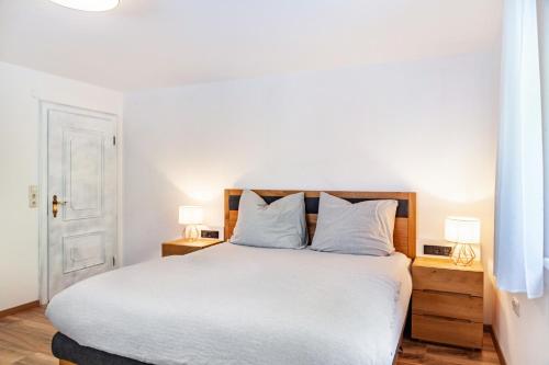 a bedroom with a large white bed with two lamps at Ferienwohnung Pfeffer in Leogang