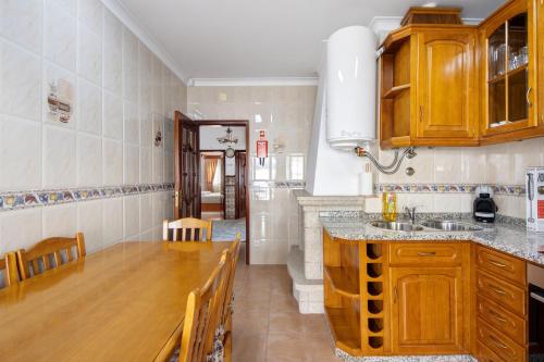 a kitchen with wooden cabinets and a wooden counter top at Casa Cimo D'Aldeia in Vila Cova de Perrinho