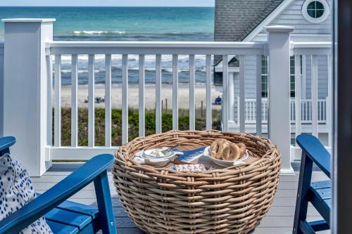 een mand op een veranda met uitzicht op het strand bij Pinewalk by Sea Scape Properties in North Topsail Beach