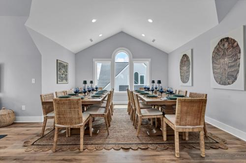 een eetkamer met een lange tafel en stoelen bij Pinewalk by Sea Scape Properties in North Topsail Beach