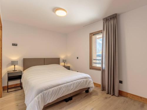 une chambre blanche avec un lit et une fenêtre dans l'établissement Appartement cosy avec balcon, parking et Wi-Fi à Champagny-en-Vanoise - FR-1-638-13, à Champagny-en-Vanoise