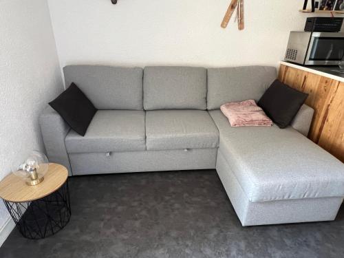 - un canapé gris dans le salon avec une table dans l'établissement Studio cabine Les Angles Capcir, aux Angles
