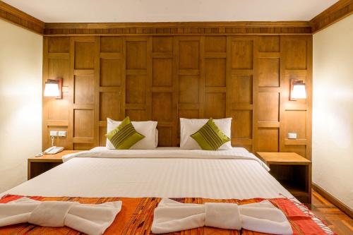 a bedroom with a large bed with wooden walls at Hua Hin Golf Villa in Hua Hin