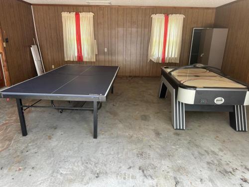 a ping pong table and a chair in a room at Best location in Matthews