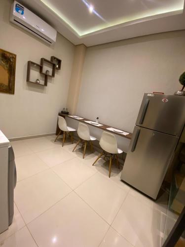 a room with a table and chairs and a refrigerator at Casa de 2 pisos Del sur 1 in Fernando de la Mora