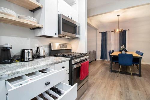 a kitchen with a table and a stove top oven at 2 Miles from NOTRE DAME - Brand New Spacious House in South Bend