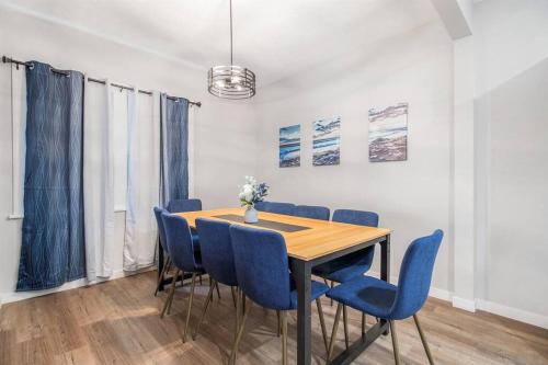 a dining room with a table and blue chairs at 2 Miles from NOTRE DAME - Brand New Spacious House in South Bend