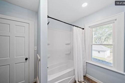 a white bathroom with a shower and a window at 2 Miles from NOTRE DAME - Brand New Spacious House in South Bend