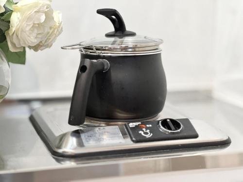 a tea kettle on top of a stove with a cell phone at Nerima house NR0250 in Tokyo
