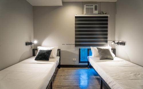 two beds are lined up in a room at Mad Monkey Manila in Manila