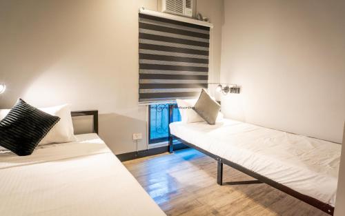 a room with two beds and a window at Mad Monkey Manila in Manila