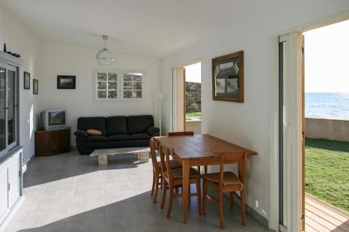 a living room with a table and a couch at Maison charmante vue mer - Erbalunga in Erbalunga