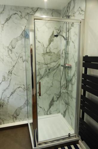 a marble shower with a glass door in a bathroom at Park Avenue Stop in Dover