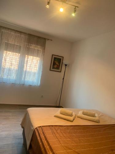a bedroom with a bed with two towels on it at Stan na dan M in Smederevska Palanka