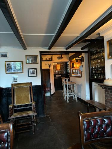 以撒港The Cornish Arms Inn的客房设有带椅子和桌子的酒吧。