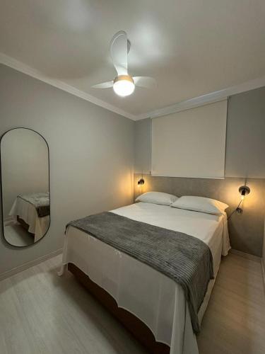a bedroom with a large bed and a mirror at Modern apartment near SESC in Franca