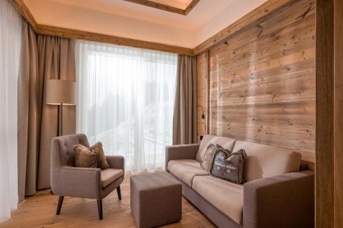 a living room with a couch and two chairs at Hotel Panorama Royal in Bad Häring