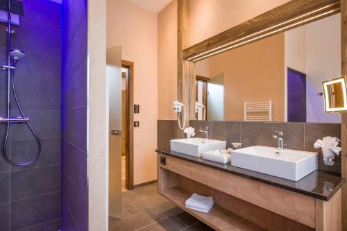 a bathroom with two sinks and a large mirror at Hotel Panorama Royal in Bad Häring