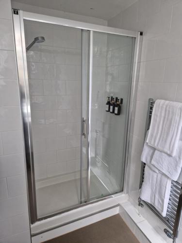 a shower with a glass door in a bathroom at Neidpath Inn in Peebles