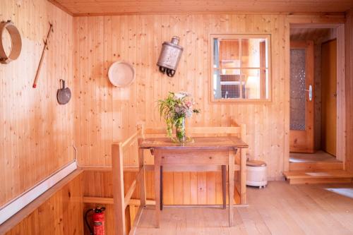 a wooden room with a table with flowers on it at Haus OmaGermana in Schoppernau