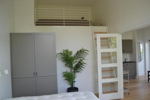 a living room with a loft bed and a plant at Hotel Lille Nyhavn in Skanderborg