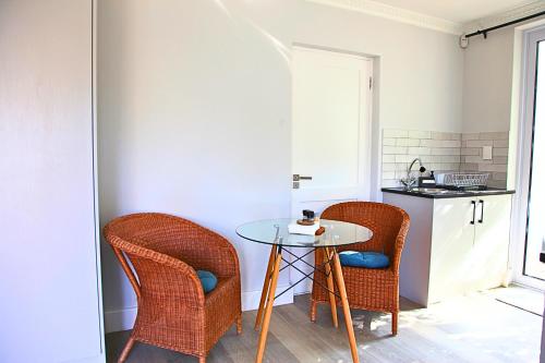 a small kitchen with a table and two chairs at The Oak Suite in Cape Town
