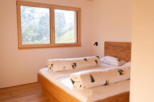two beds in a room with a window at Haus Kanabe in Schoppernau