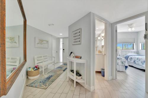 a room with a bedroom with a bed and a mirror at Cheerful Oasis on Anna Maria Island in Bradenton Beach