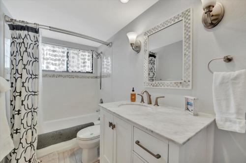a white bathroom with a sink and a toilet at Cheerful Oasis on Anna Maria Island in Bradenton Beach