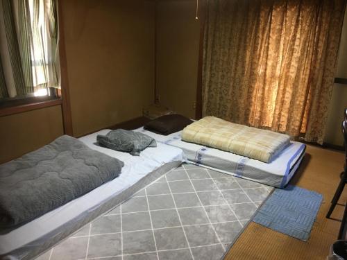 two beds sitting on the floor in a room at Narita Airport Samurai Guesthouse -In front of Train Station- in Katori
