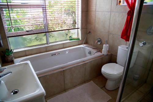 a bathroom with a tub and a toilet and a sink at Terryton Country Estate in Gonubie