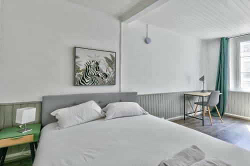 une chambre avec un grand lit blanc et un bureau dans l'établissement Superbe appartement à 10 min du Vieux Port, à Marseille