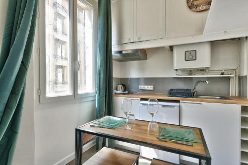 - une petite cuisine avec une table et deux verres à vin dans l'établissement Superbe appartement à 10 min du Vieux Port, à Marseille