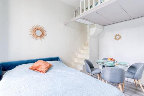 a bedroom with a bed and a table and chairs at Charming Apartment - Near City Center, AC Included in Maisons-Alfort