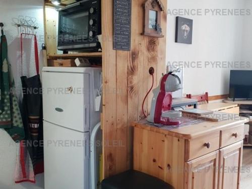 Il comprend une cuisine équipée d'un réfrigérateur blanc et d'un comptoir avec une table. dans l'établissement Charmant T2 lumineux avec loggia et coin cabine - Bien équipé - FR-1-295-190, aux Angles