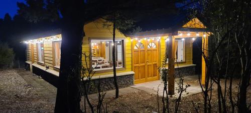 a small yellow house with lights on it at night at Criollo Restó & Cabañas in Trevelin