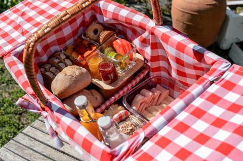 マンテイガスにあるManteigas Loversのピクニックテーブルの上に食べ物が詰まったピクニックバスケット