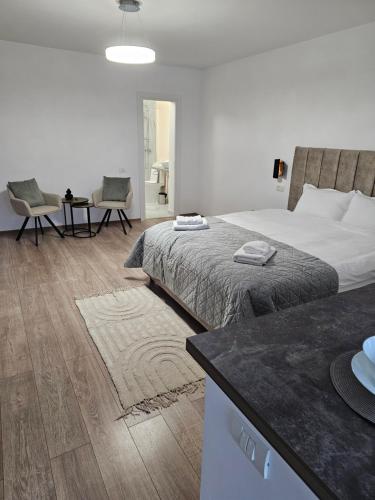 a bedroom with a large bed and a table and chairs at Terrace Green Hill House in Braşov