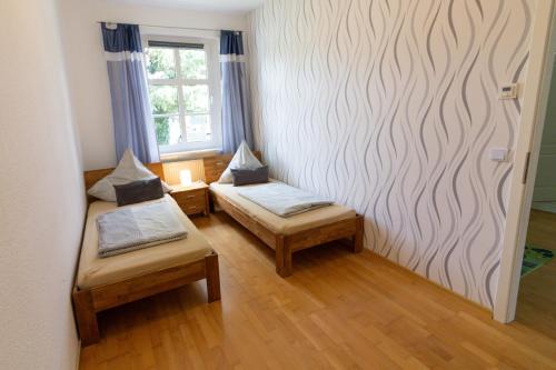 a small room with two beds and a window at Ferienwohnung Pasewalk, 110 qm mit Geschirrspüler in Papendorf