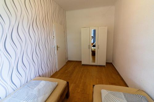 a room with two beds and a hallway with a mirror at Ferienwohnung Pasewalk, 110 qm mit Geschirrspüler in Papendorf