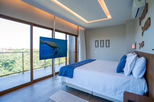 a bedroom with a bed and a large window at Casa Oceano- Praia do Forte in Praia do Forte