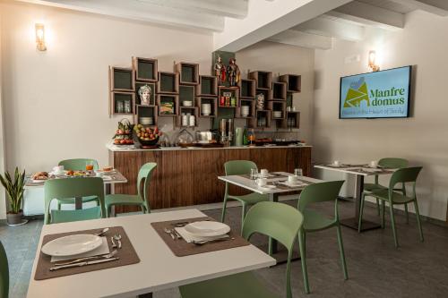 a dining room with tables and green chairs at Manfredomus in Mussomeli